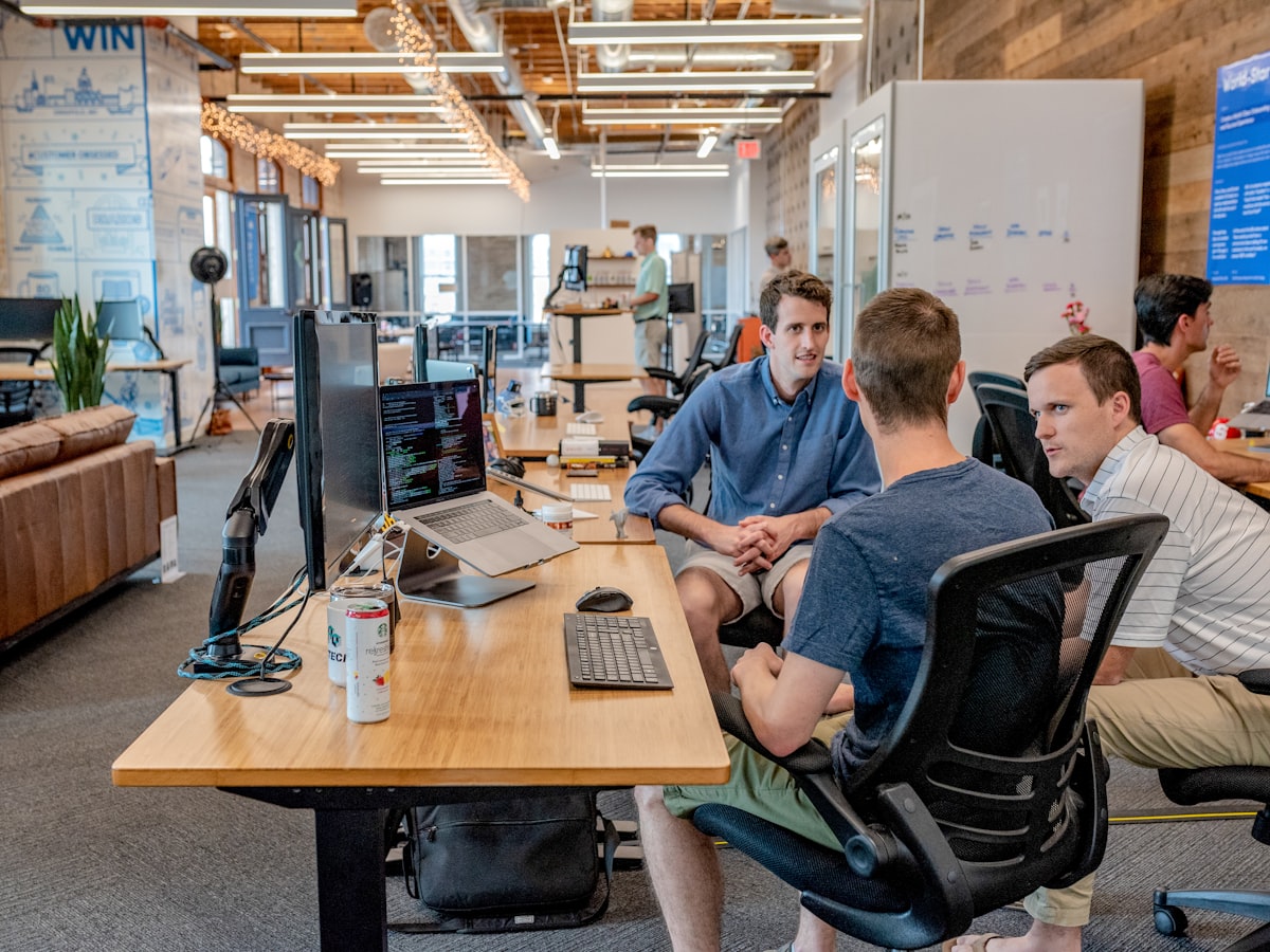 A team in working conversation around their desks